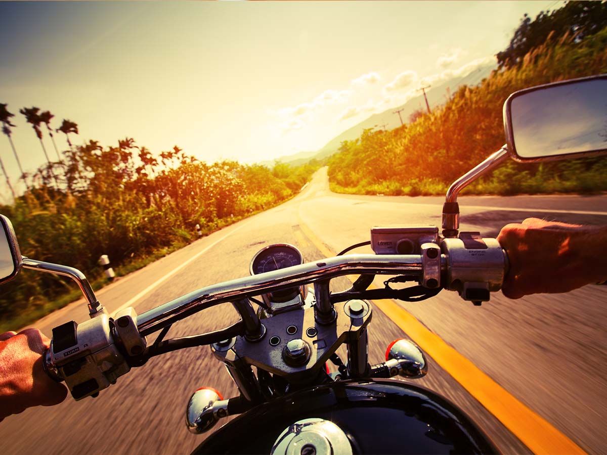  A view over the handlebars of a bike riding down the highway. 