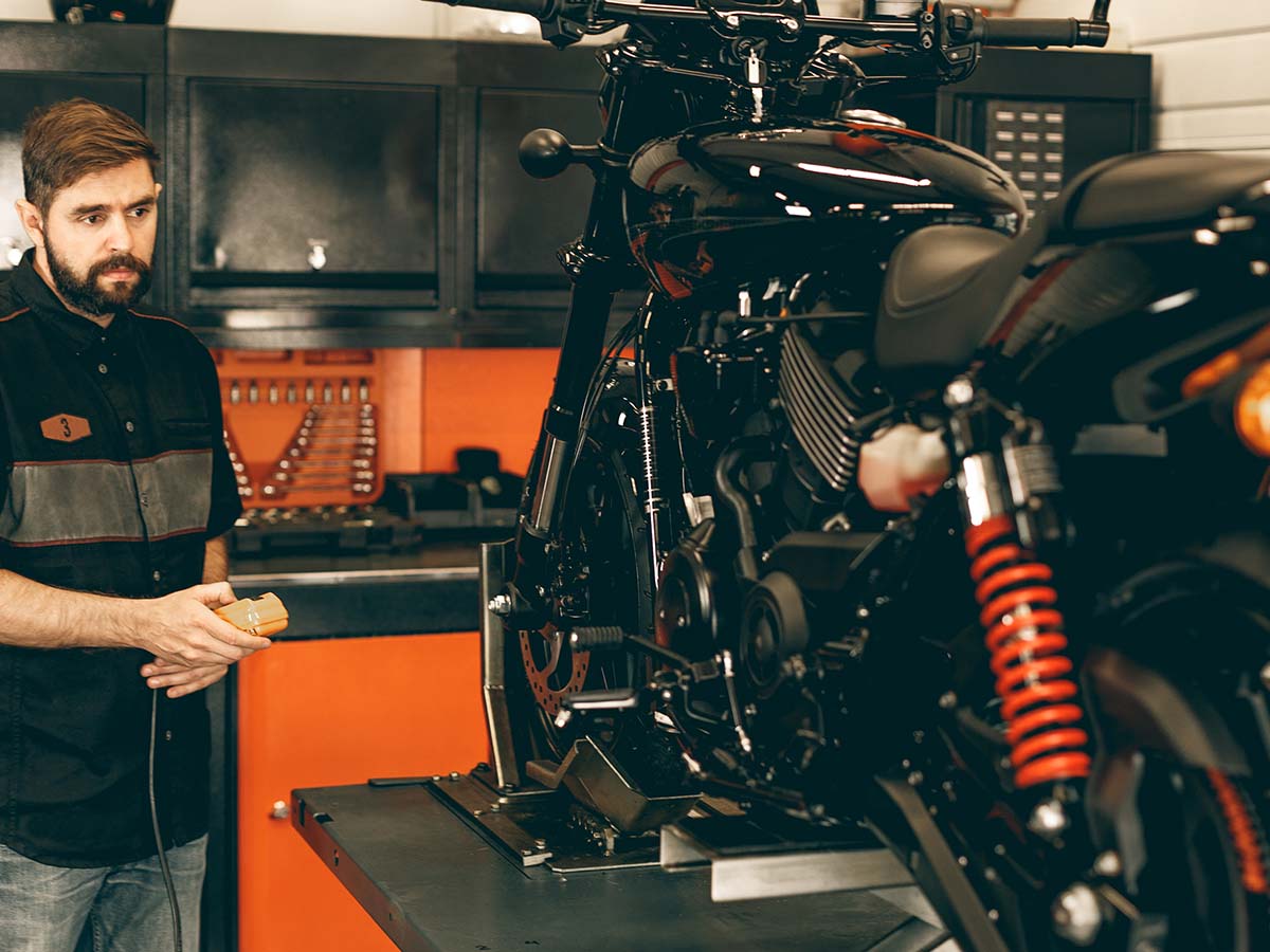 A technician standing next to a bike he’s working on.